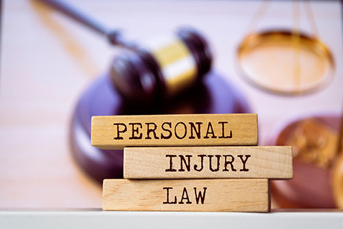 Personal Injury Law wooden blocks with gavel and scale in background - Pigott Law Group